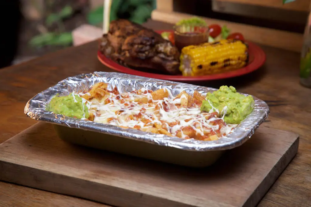 Papas gratinadas con queso, tocino, salami y guacamole